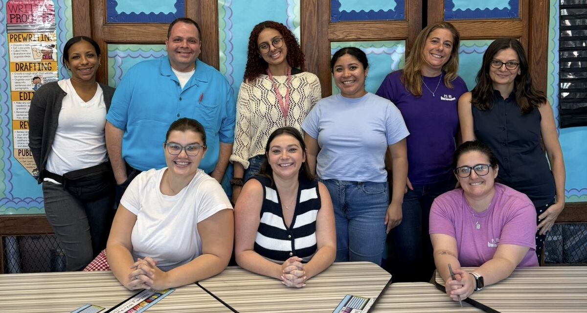 The 3rd Grade teaching team posing together in a classroom, some seated at the front.
