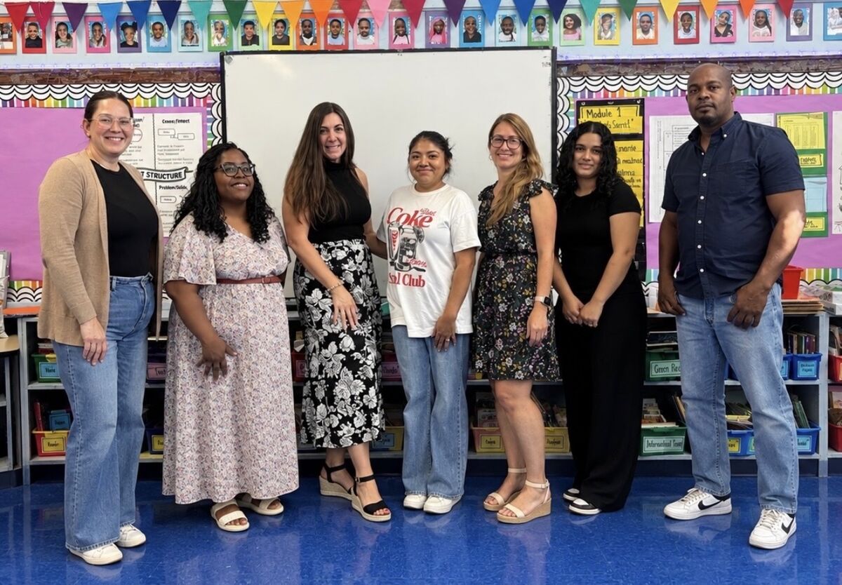 The 5th Grade teaching team standing together in a brightly decorated classroom.
