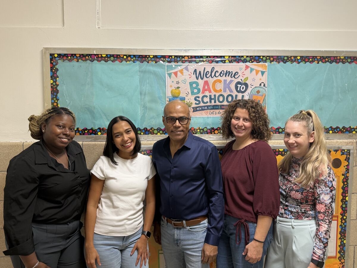 Members of the Guidance & Counseling team standing together in front of a Welcome Back to School bulletin board.